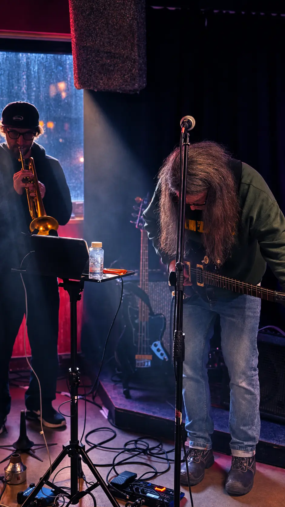 Trumpet and guitar players performing live on stage